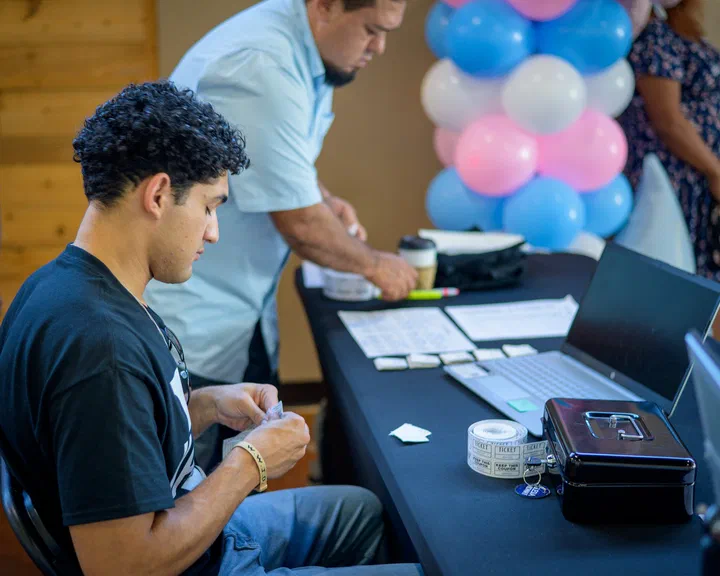 Un joven y un hermano preparando la mesa de registro