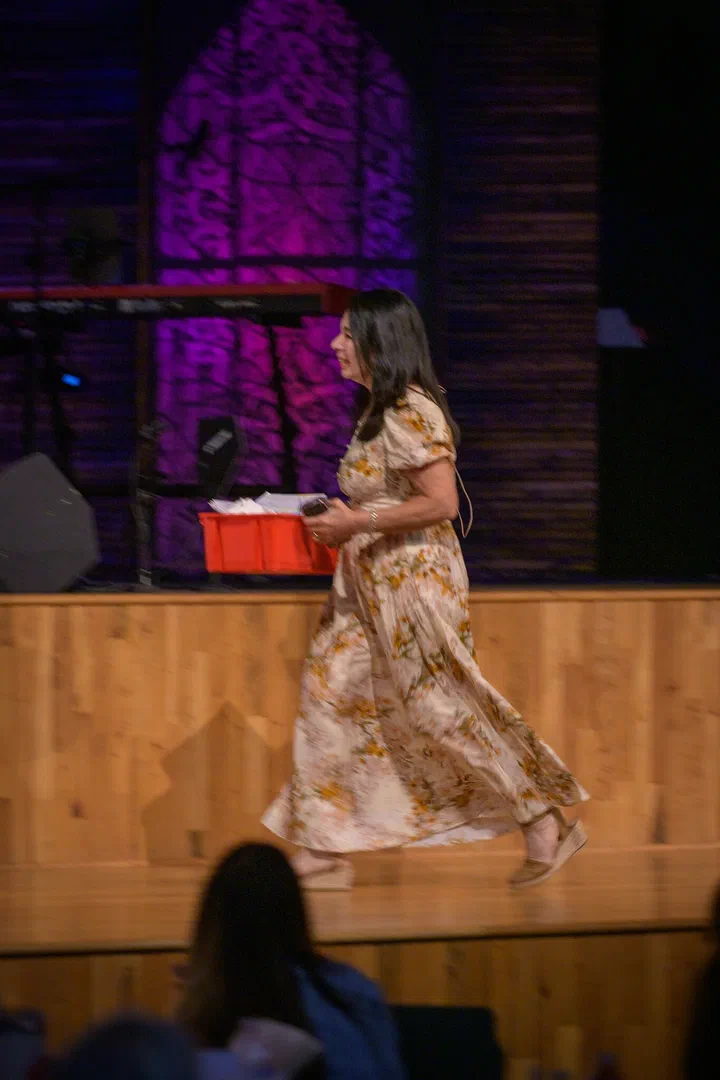 Yanina Todd caminando a la tarima con una caja roja