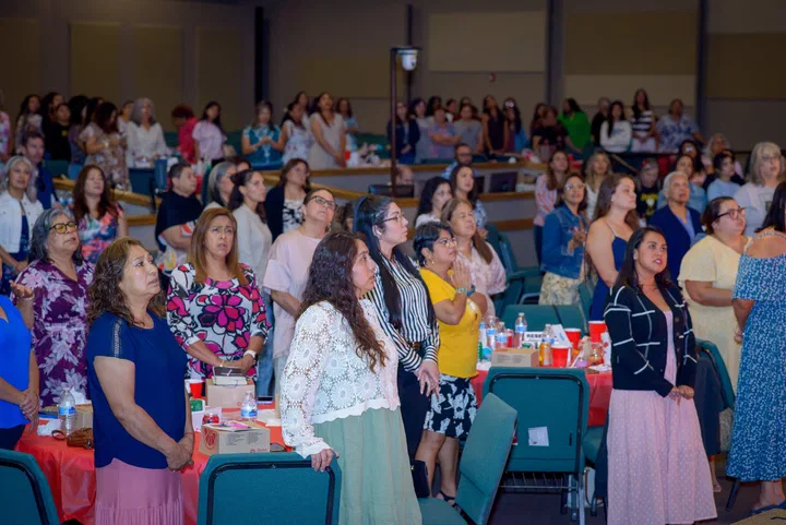 Las mujeres de pie en la alabanza