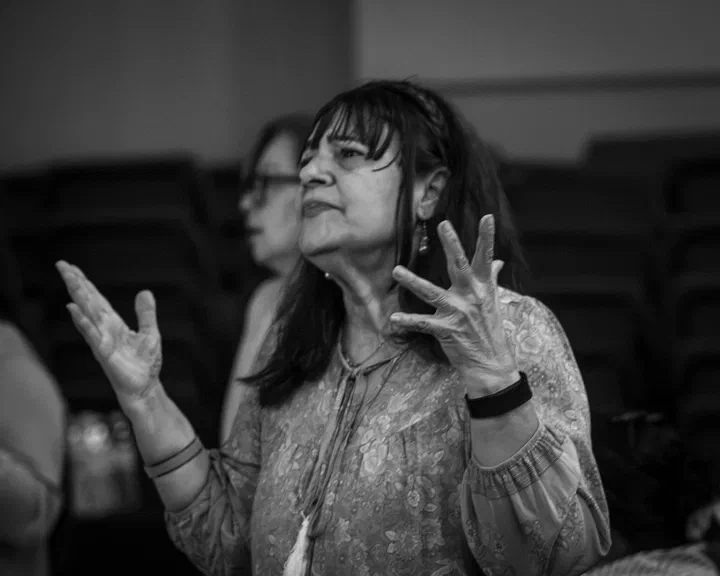 Hermana adorando con las manos abiertas, en blanco y negro