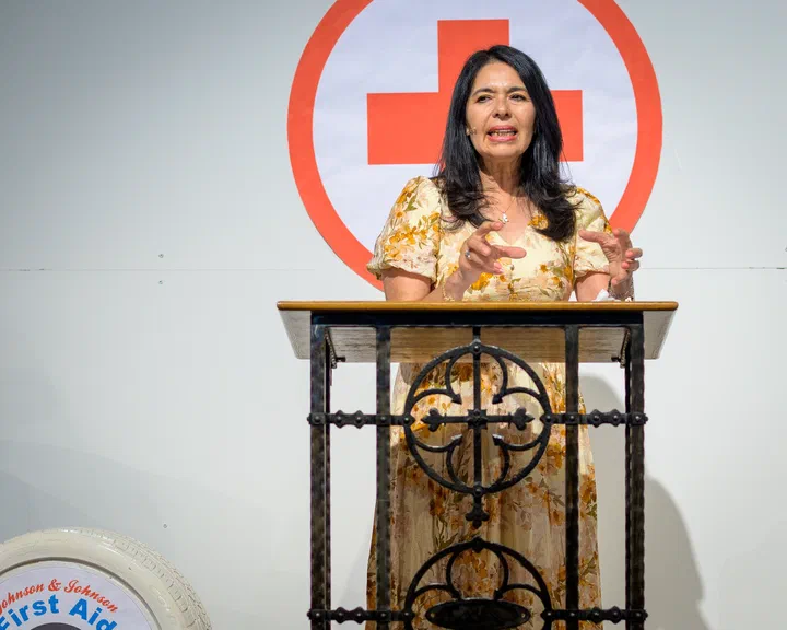 Yanina Todd hablando desde el púlpito, con las manos abiertas