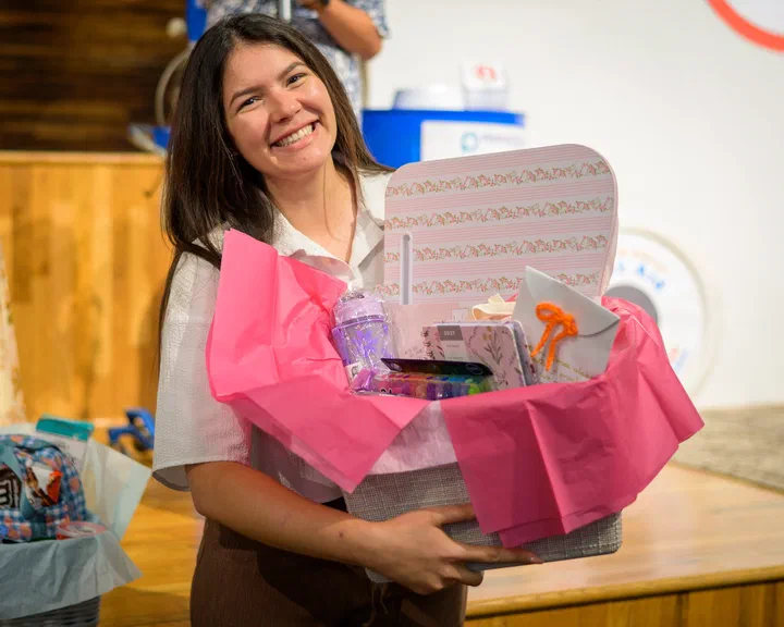 Joven con una canasta rosada de regalo