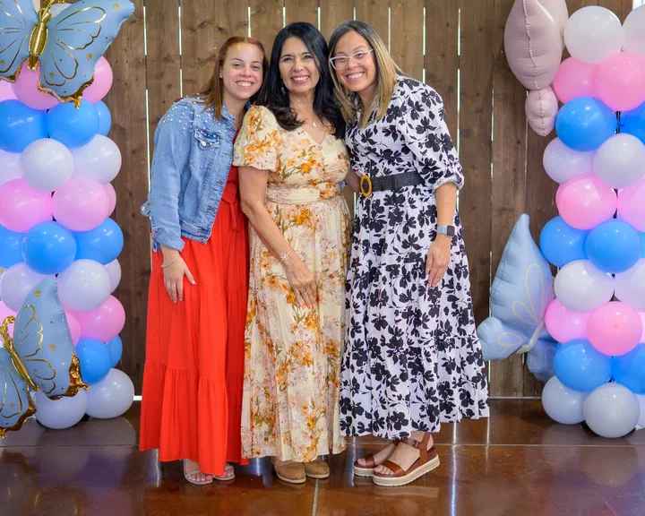 Yanina Todd con dos hermanas; una de vestido rojo