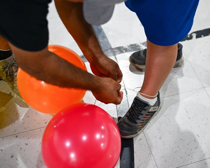 Amarrando un globo al tobillo de un niño