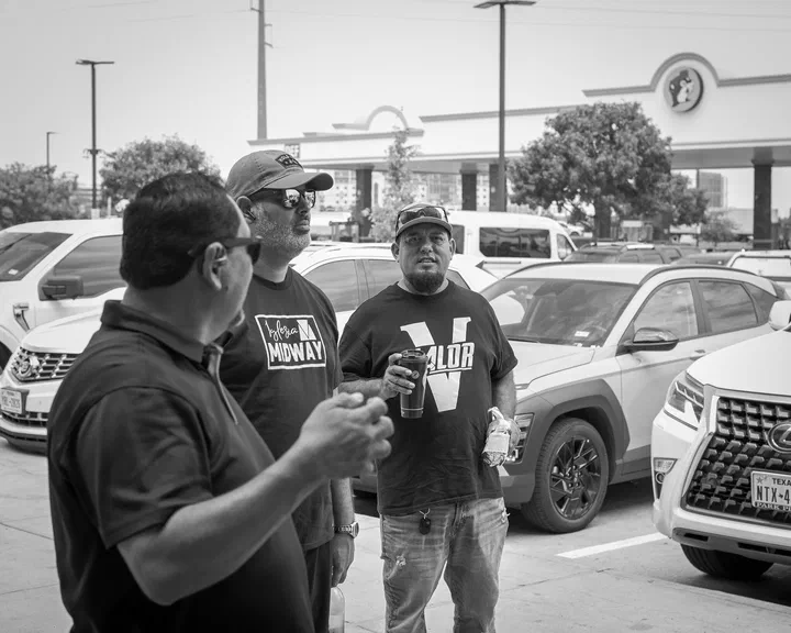 Conversación en el estacionamiento durante la parada, con camisas de Valor