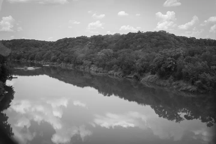 El río refleja las nubes y los árboles