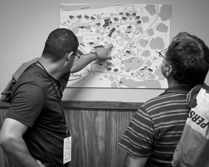 Dos hermanos buscando su cabaña en el mapa del campamento