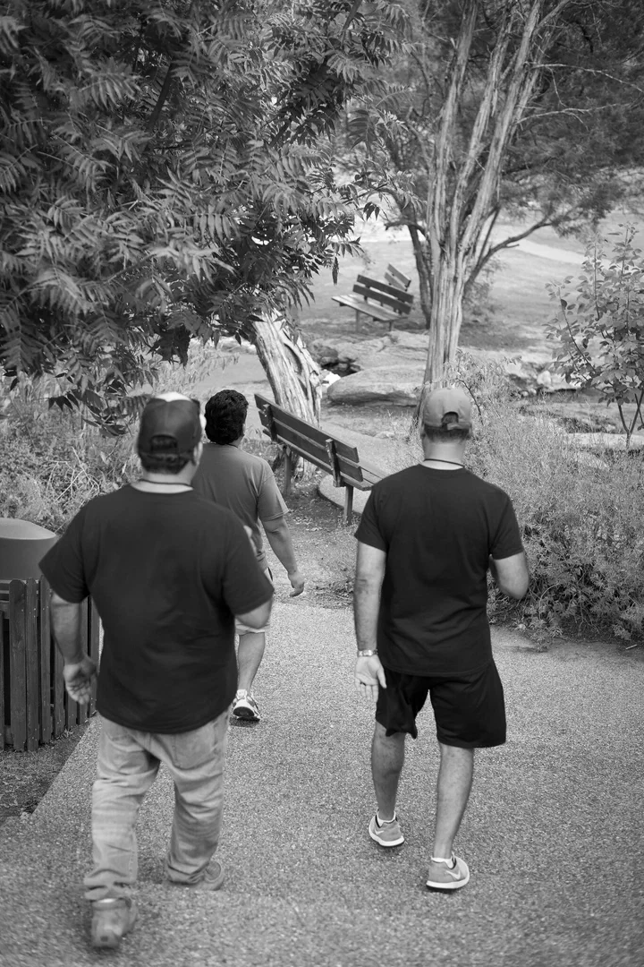 Tres hermanos bajando por un camino entre los árboles